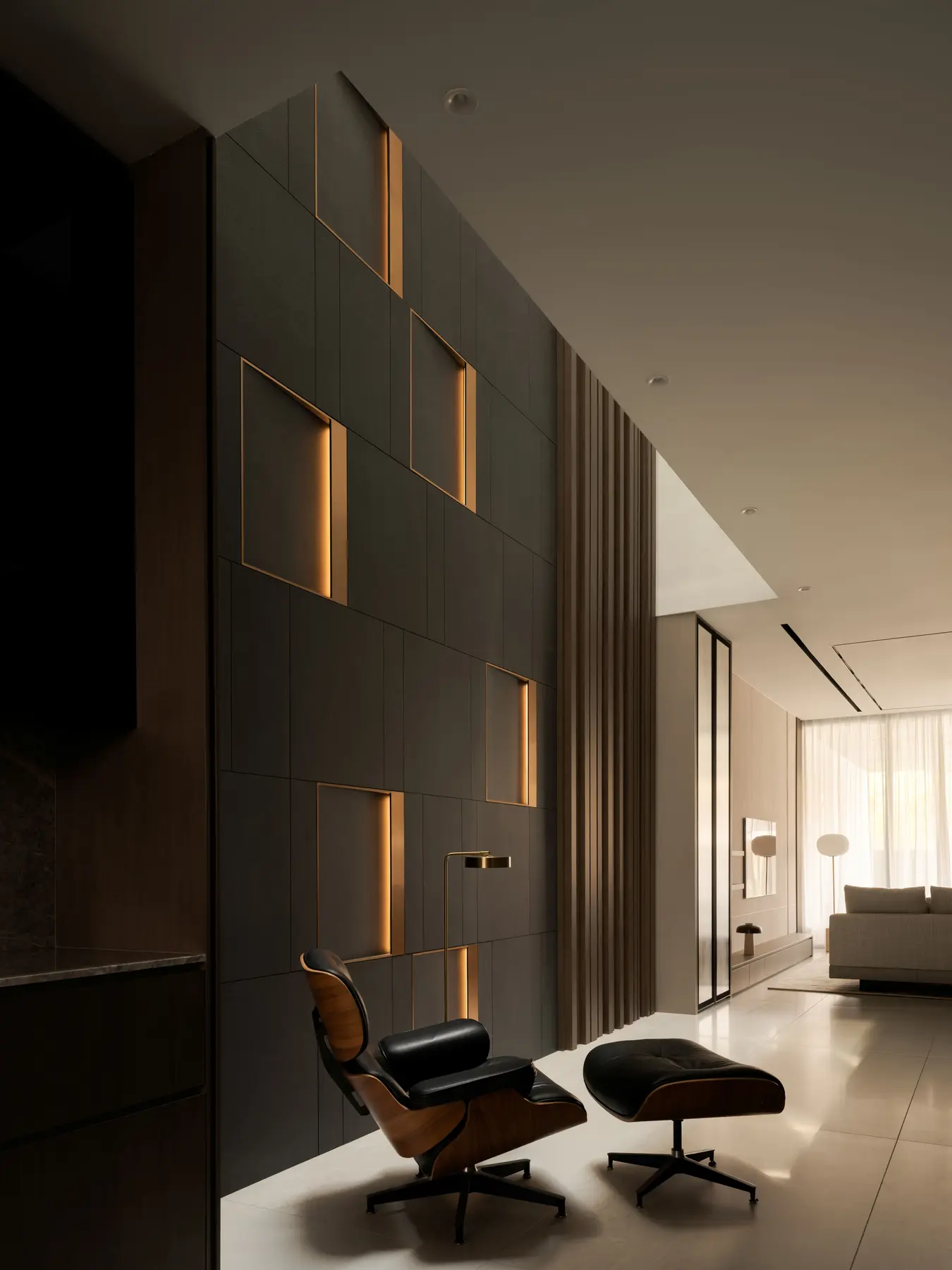 Feature wall — dark stone-effect panels with backlit gold reveals and Eames lounge chair