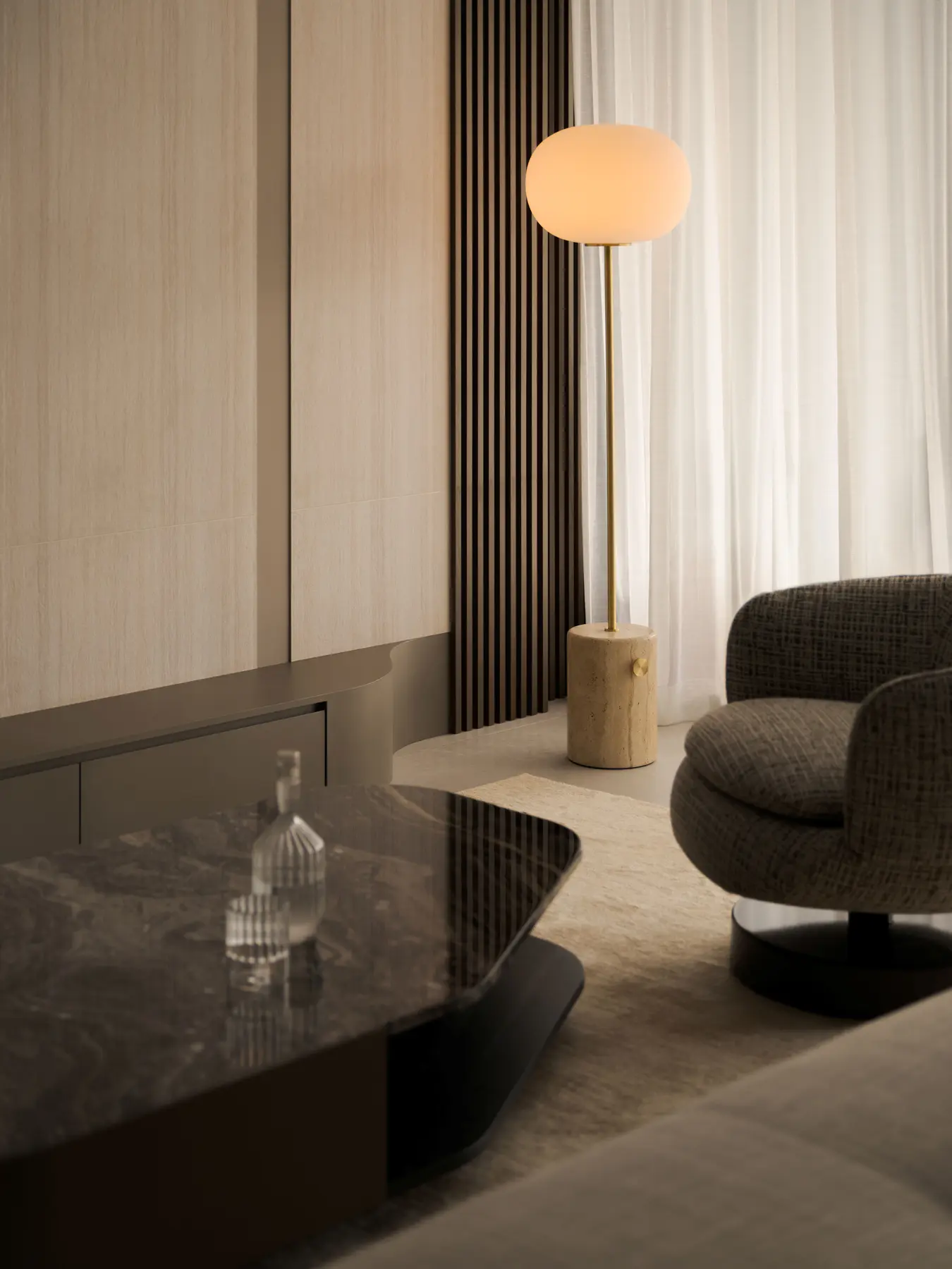 Living room — globe floor lamp on travertine base beside boucle lounge chair