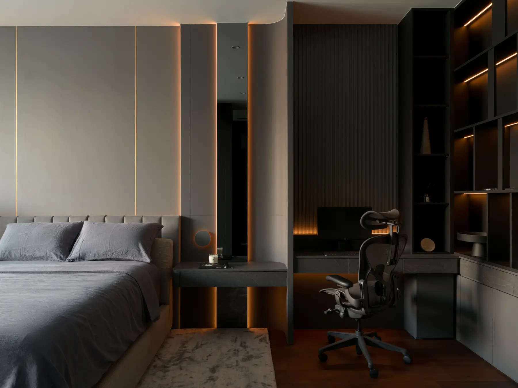 Master bedroom — full width with gold-lit panel headboard, integrated study nook and dark shelving